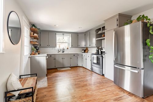 Kitchen with gray shaker cabinets, subway tile backsplash, and stainless refrigerator