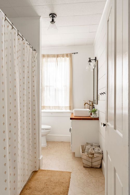 Bathroom with shiplap walls, a vessel sink on a wood counter, and a shower curtain