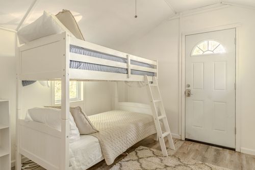 Bunkroom with a white bunk bed and a paned glass exterior door.