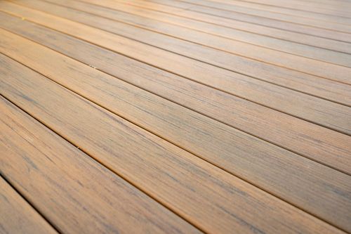 Close-up detail of tan composite deck boards with wood-grain texture