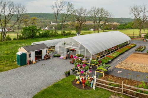 Aerial view of a greenhouse nursery with potting shed and flowering plants for sale