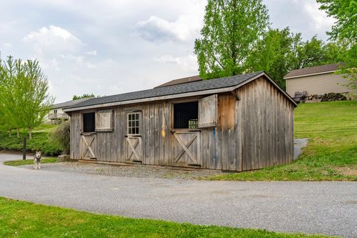 Rear view of a brick ranch home with wraparound wood deck and walkout lower level