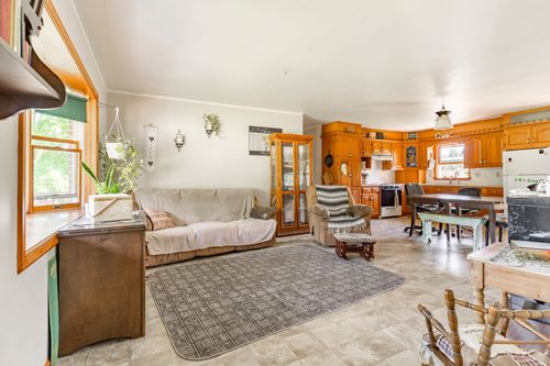 Living room with oak built-in cabinetry, sectional sofa and open sightline into the kitchen