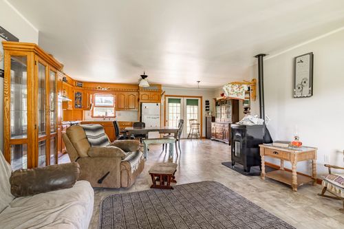 Living room with freestanding wood stove, oak built-ins and open dining area beyond