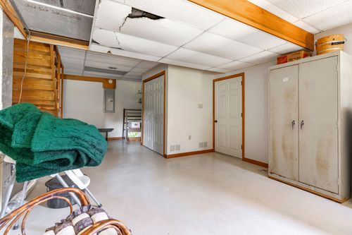 Basement storage room with metal utility cabinets and closet doors along a concrete floor