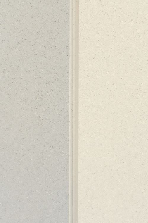 Close-up seam between gray and cream metal wall panels