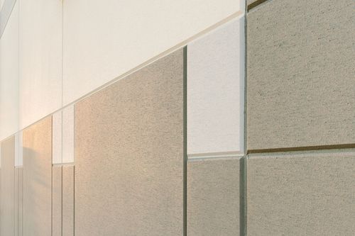 Angled close-up of textured metal wall panels in a warm gradient of tones