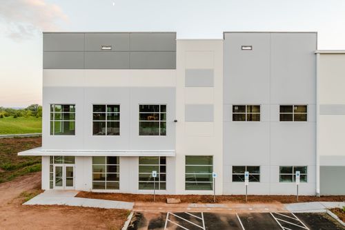 Loading dock with a white overhead door and gray-and-white two-tone metal panel siding