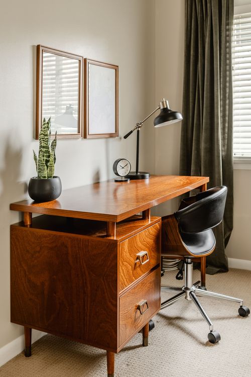 Vintage wood desk with brass hardware, task lamp and framed art above