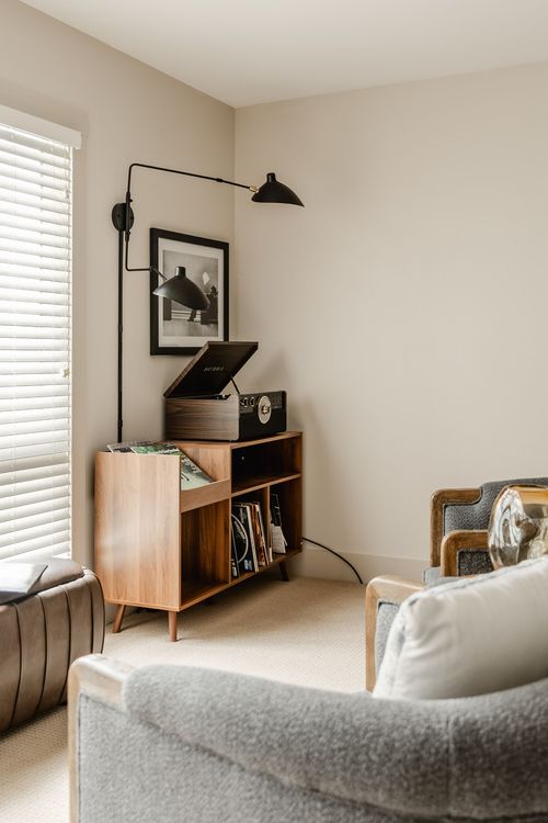 Corner turntable stand with a wall-mounted swing-arm lamp and framed print