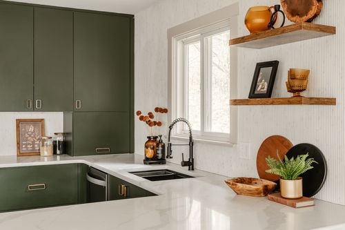 Kitchen sink area with black fixtures, floating wood shelves and amber glassware display