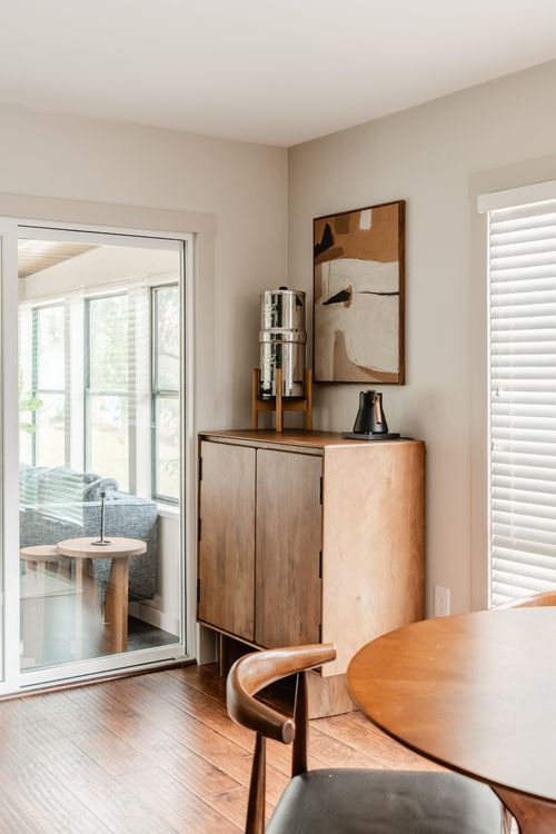 Corner coffee station with a wood cabinet, abstract art print and stainless water filter