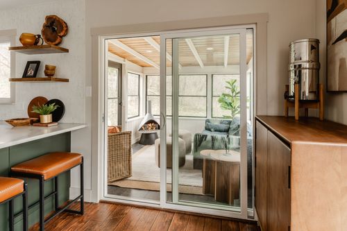 Kitchen counter beside sliding glass doors leading to a screened sunroom