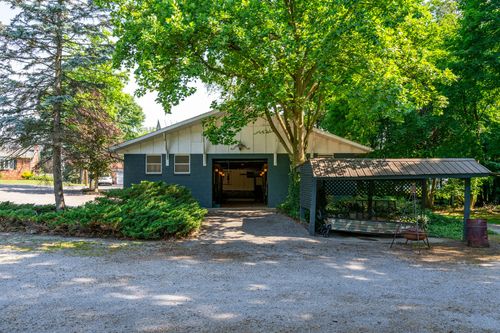 Barn-style garage with an open bay and a covered porch swing to the side