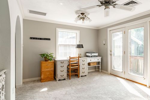 Compact home office nook with a small desk beside French balcony doors