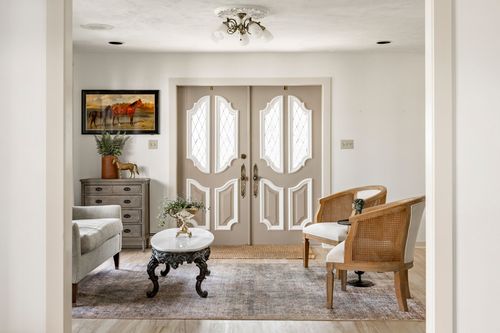 Sitting room with diamond leaded-glass doors, a gray dresser and cane armchair