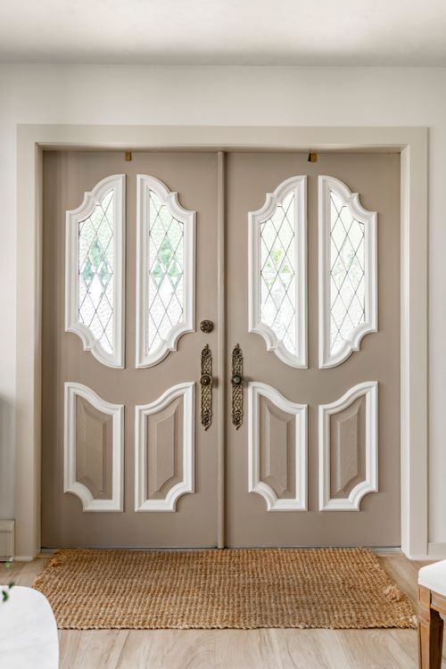 Double front doors with diamond leaded-glass panels set in a taupe frame