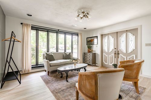 Living area with a wall of windows, cane chairs and a valet stand