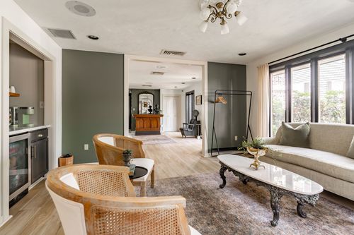 Family room with a built-in wine fridge bar, cane chairs and an oval coffee table