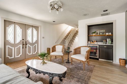 Entry room with leaded-glass double doors, a wet bar and staircase beyond