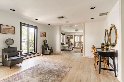 Salon seating area with vintage hooded dryer chairs and a glass door to the deck