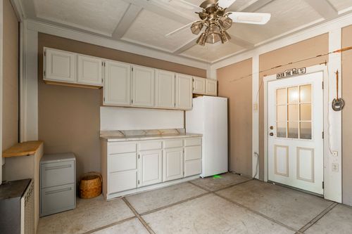 Mudroom with white cabinetry, a coffered ceiling and a glass-paneled entry door