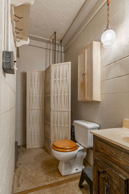 Barn bathroom with a folding privacy screen, hanging pendant light and wood vanity