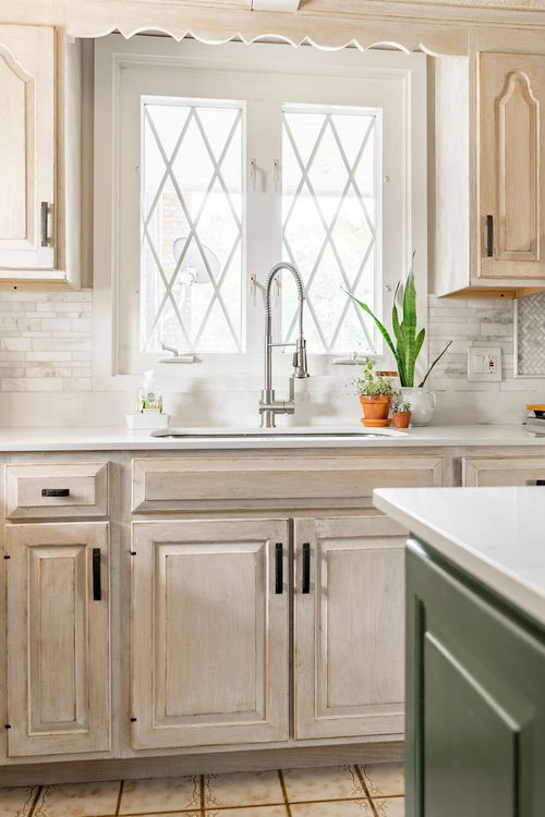 Kitchen sink nook with diamond leaded-glass windows and cream cabinetry