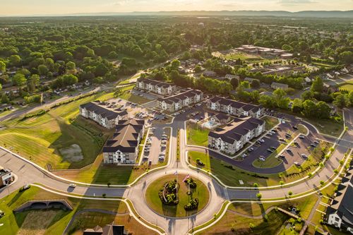 Aerial view of a roundabout with flagpoles framed by apartment buildings