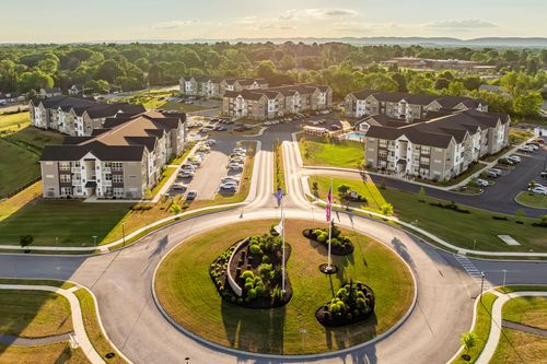Aerial view of apartment buildings and a roundabout with a mountain ridge backdrop