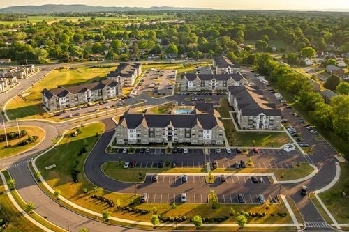 Aerial view of the complex with a pool and roundabout, mountains in the distance