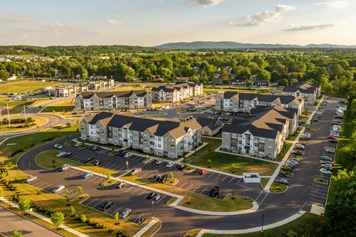 Aerial view of apartment buildings and parking lots with a mountain ridge beyond