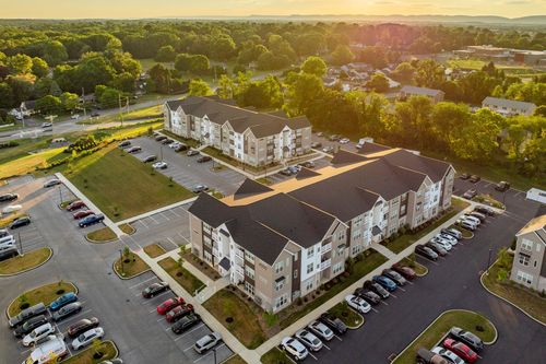 Aerial view of two apartment buildings with parking lots glowing at sunset