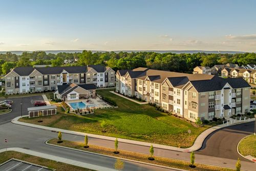 Aerial view of the pool and clubhouse pergola with water visible in the distance