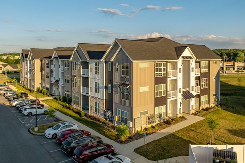 Aerial dusk view of multi-story apartment buildings with landscaped parking areas