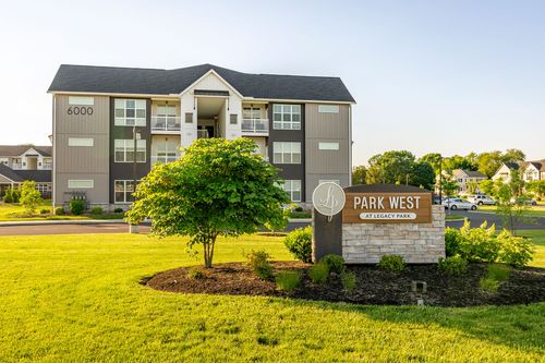 Park West community sign framed by landscaping with the apartment building behind