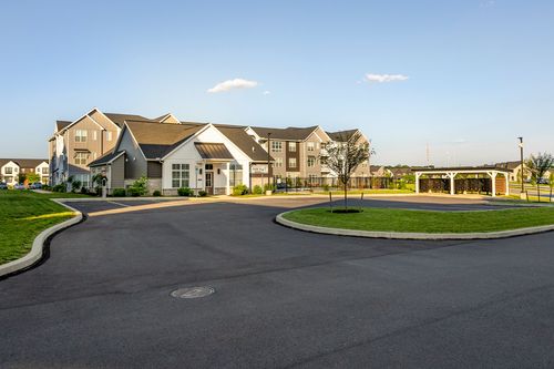 Apartment complex clubhouse with a circular drive at dusk