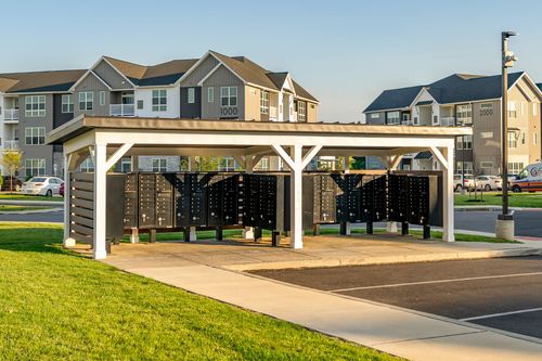 Covered mail kiosk with rows of cluster mailboxes at golden hour