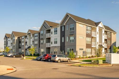 Apartment building exterior with mixed siding tones and cars parked below