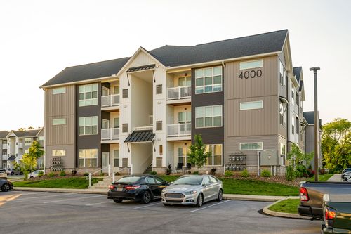 Building 4000 exterior with a covered entry stoop and parked cars