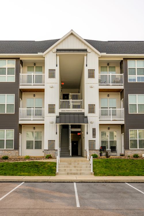 Symmetrical apartment building entrance with stairs and wraparound balconies