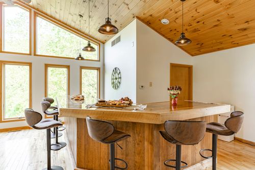 Wood kitchen island set with a charcuterie spread and leather swivel bar stools