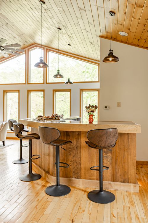 Kitchen bar with pendant lighting beneath a vaulted wood-paneled ceiling