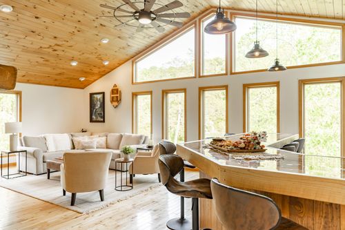 Living room sectional beside a kitchen bar set with a charcuterie board