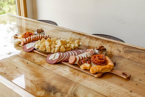 Charcuterie board with meats, cheeses, crackers and pretzels on a wood counter