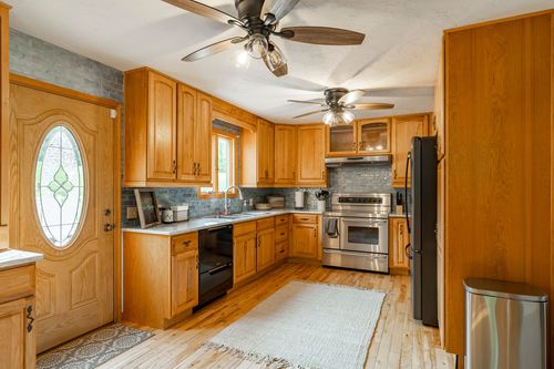 Kitchen with oak cabinetry, stainless steel appliances and a tile backsplash