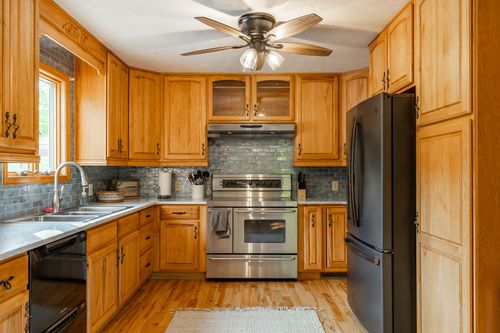 Kitchen with a farmhouse-style window over the sink and stainless steel appliances
