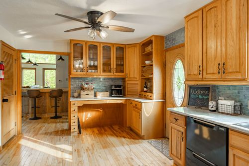 Kitchen desk nook with glass-front cabinets and a built-in coffee station