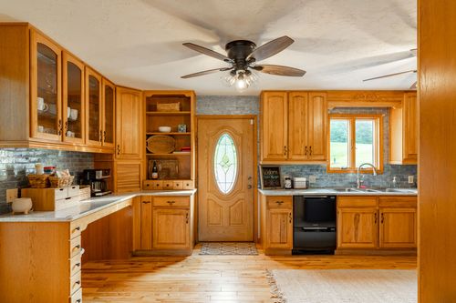 Kitchen with oak cabinets opening to an entry door with an oval glass window