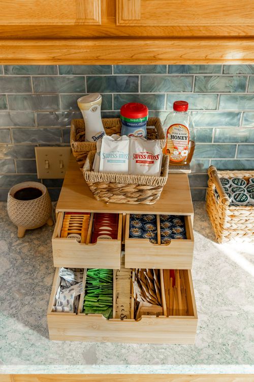 Wood coffee and tea organizer with drawers of packets on a marble countertop